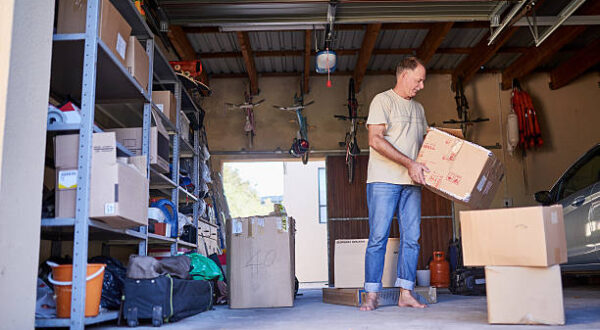 Shot of a man carrying a box in a garage